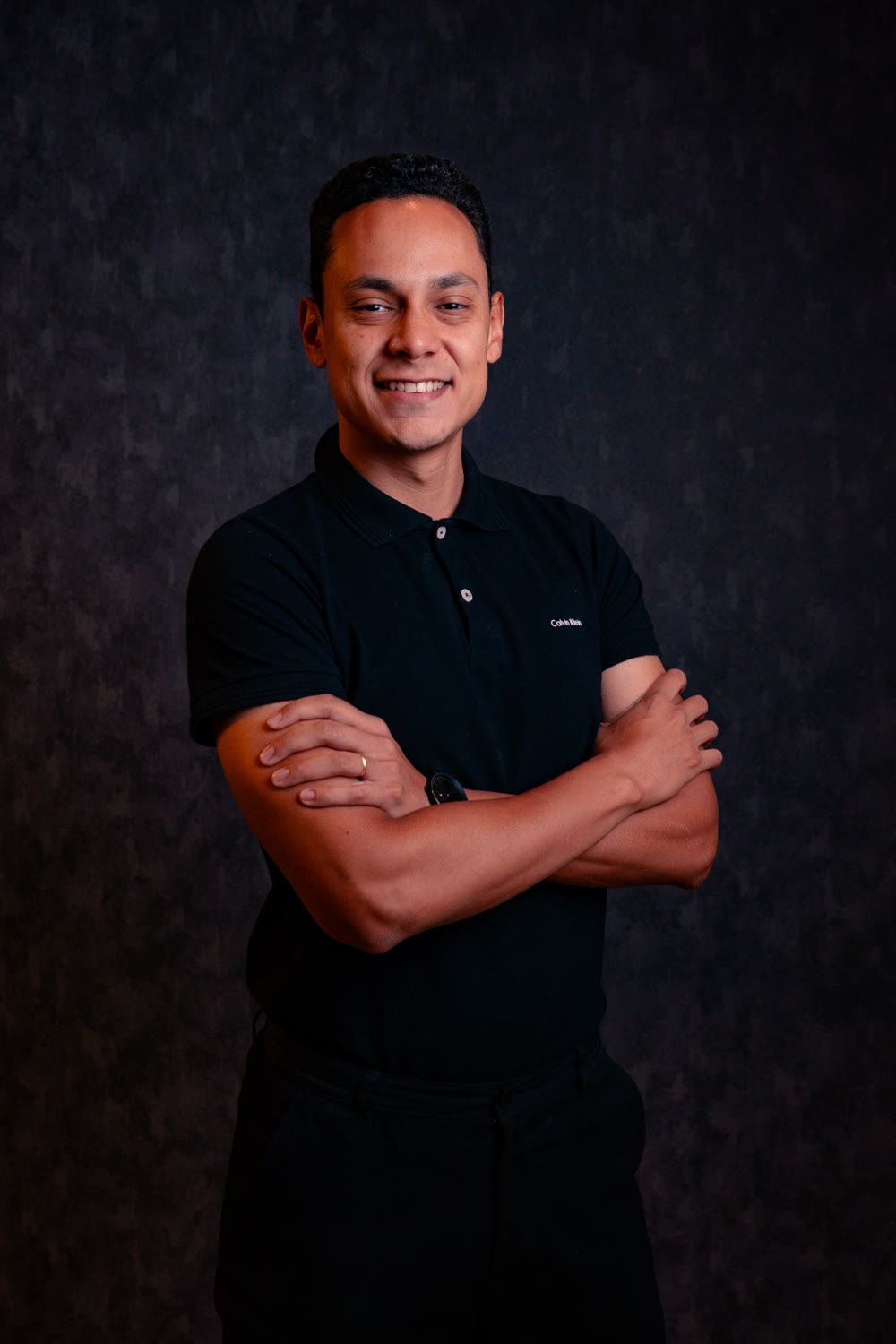 Thiago Rodrivera, criador do Teu Dinheiro, de braços cruzados em um retrato de estúdio.